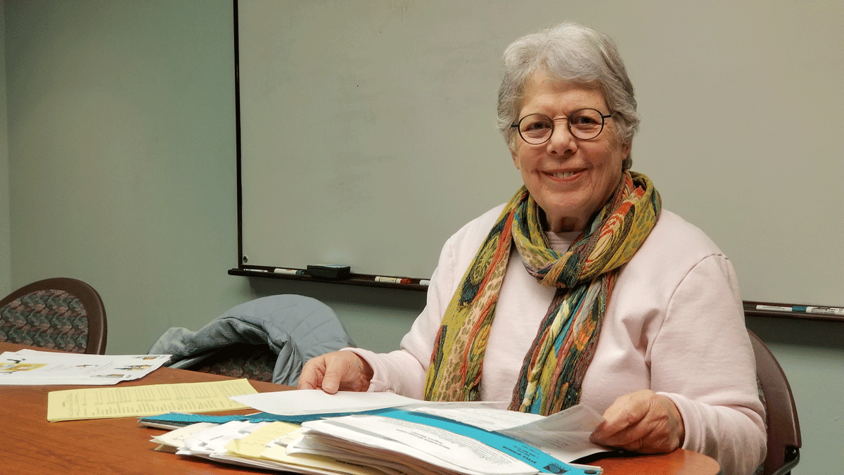Marian Hogins organizes client paperwork as a volunteer at River of Refuge utilizing the skills she developed during a career in healthcare administration